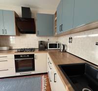 Vkusný 3 izb. byt po kompl. rekonštrukcii - Jilemnického ulica -72m2 - Kuchynská linka v 3-izbovom byte s podlahou s dreveným dekorom a spotrebičmi.