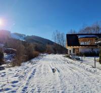 Chata pri SKI Mýto pod Ďumbierom Nízke Tatry - Zasnežená cesta pred chatou na ulici v Mýte pod Ďumbierom, za slnečného zimného dňa.
