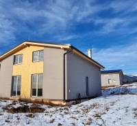 Únik z mesta, kde sa moderná architektúra stretáva s divokou prírodou? - Chata v Dolnej Lehote s dreveným obkladom, zasnežená krajina a hory na obzore.