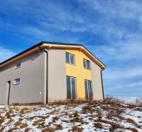 Únik z mesta, kde sa moderná architektúra stretáva s divokou prírodou? - Chata v Dolnej Lehote s dreveným dekorom, zasnežený pozemok a zamračená obloha.