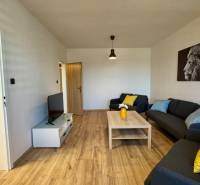 NA PRENÁJOM veľký 3 izbový byt na Čermáni NITRA - Obývacia izba v 3-izbovom byte s pohovkami a podlahou s dreveným dekorom.