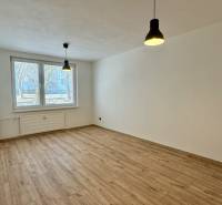 NA PRENÁJOM veľký 3 izbový byt na Čermáni NITRA - Priestranná izba v 3-izbovom byte s podlahou s dreveným dekorom a visiacimi lampami.