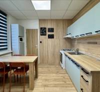 NA PRENÁJOM veľký 3 izbový byt na Čermáni NITRA - Kuchyňa v 3-izbovom byte s jedálenským stolom a podlahou s dreveným dekorom.