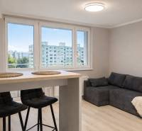 Prenájom 2-izbový byt s loggiou, 54m2, Bratislava-Petržalka - Obývacia izba v 2-izbovom byte s pohovkou, barovým stolom a stoličkami.