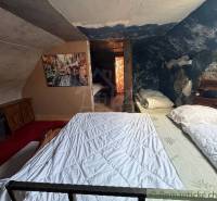 Štýlová chalupa v horskej dedinke Ratkovské Bystré - Podkrovná spálňa v rodinnom dome s obrazom a modrou stenou plnou vzorov.