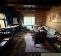 Štýlová chalupa v horskej dedinke Ratkovské Bystré - Obývačka v rodinnom dome s podlahou s dreveným dekorom a pohodlným sedením.