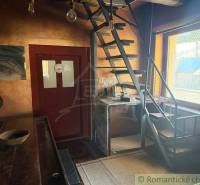 Štýlová chalupa v horskej dedinke Ratkovské Bystré - Interiér rodinného domu s kovovým schodiskom a dreveným stolom, svetlé steny.