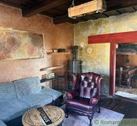 Štýlová chalupa v horskej dedinke Ratkovské Bystré - Obývacia izba v rodinnom dome s koženým kreslom a kachľovou pecou.