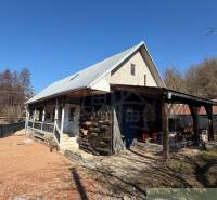 Štýlová chalupa v horskej dedinke Ratkovské Bystré - Rodinný dom v Ratkovskom Bystrom so sedlovou strechou a drevenou verandou.