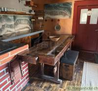 Štýlová chalupa v horskej dedinke Ratkovské Bystré - Rustikálna kuchyňa v rodinnom dome s tehlovými detailmi a podlahou s dreveným dekorom.