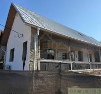 Štýlová chalupa v horskej dedinke Ratkovské Bystré - Rodinný dom v Ratkovskom Bystrom so záhradou, bielou fasádou a kovovou strechou.