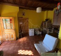 Exkluzívne: Pekná chalupa v obci Lipovec - Izba v rodinnom dome s tehlovou podlahou, dreveným stropom a žltými stenami.