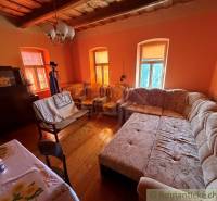 Exkluzívne: Pekná chalupa v obci Lipovec - Obývacia izba v rodinnom dome s veľkým gaučom a podlahou s dreveným dekorom.