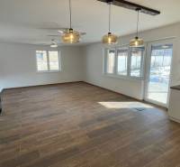 Rodinný dom na Devätinovej ulici na prenájom - Priestranný obývací priestor s podlahou s dreveným dekorom v rodinnom dome.