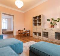 3-izbový byt s vysokými stropmi, Staré Mesto - Obývacia izba v 3-izbovom byte s podlahou s dreveným dekorom a pastelovými stenami.