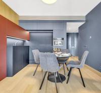 Predaj luxusný 2-izbový byt, 52 m2, Továrenská ul, SKY PARK - Moderná kuchyňa s jedálenským stolom, sivými stoličkami a podlahou s dreveným dekorom v 2-izbovom byte.