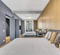 Predaj luxusný 2-izbový byt, 52 m2, Továrenská ul, SKY PARK - Spálňa v 2-izbovom byte s podlahou s dreveným dekorom a zrkadlovou stenou.