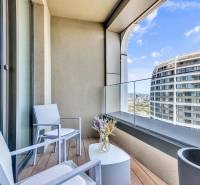 Predaj luxusný 2-izbový byt, 52 m2, Továrenská ul, SKY PARK - Balkón s podlahou s dreveným dekorom a výhľadom na mesto zo 2-izbového bytu.