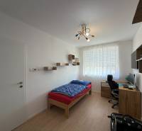 3-izbový byt s garážovým státím – Košice Západ, ul. Topoľčianska - Detská izba v 3-izbovom byte s podlahou s dreveným dekorom, písacím stolom, posteľou.