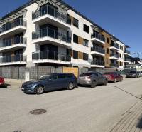 3-izbový byt s garážovým státím – Košice Západ, ul. Topoľčianska - Nové bytové domy na Topoľčianskej ulici v Košiciach, mestská časť Západ s autami zaparkovanými vpredu.