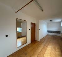 Exk. viacgeneračný RD vo Veľkom Orvišti pri Piešťanoch REZERVOVANÝ - Izba v rodinnom dome s podlahou s dreveným dekorom, zrkadlom a oknom.