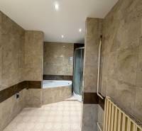 Exk. viacgeneračný RD vo Veľkom Orvišti pri Piešťanoch REZERVOVANÝ - Kúpeľňa v rodinnom dome s obkladom mramorového vzhľadu a rohovou vaňou.