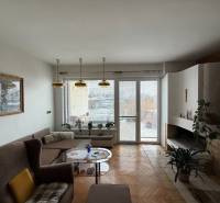 Exk. viacgeneračný RD vo Veľkom Orvišti pri Piešťanoch REZERVOVANÝ - Obývačka v rodinnom dome s krbom, sedačkou a podlahou s dreveným dekorom.