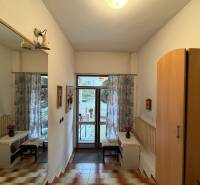 Exk. viacgeneračný RD vo Veľkom Orvišti pri Piešťanoch REZERVOVANÝ - Interiér rodinného domu so zrkadlom, skriňou, dlažbou a pohľadom na záhradu.