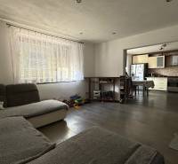 Moderný 5-izbový rodinný dom po kolaudácii 2025 | 2-generačné bývanie  - Obývačka v rodinnom dome s pohľadom na kuchyňu, podlaha s dreveným dekorom.