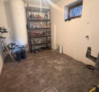 Moderný 5-izbový rodinný dom po kolaudácii 2025 | 2-generačné bývanie  - Skladový priestor v rodinnom dome s regálom a športovým vybavením, podlaha s dreveným dekorom.