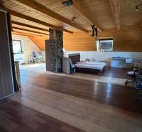 Moderný 5-izbový rodinný dom po kolaudácii 2025 | 2-generačné bývanie  - Podkrovná izba s posteľou, skriňou a podlahou s dreveným dekorom v rodinnom dome.