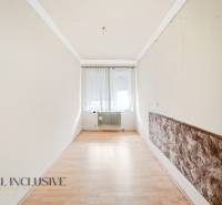 Na predaj 4-izbový rodinný dom, Topoľníky - Úzka izba s podlahou s dreveným dekorom, okno so záclonami, radiátor.