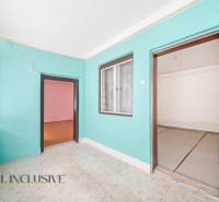 Na predaj 4-izbový rodinný dom, Topoľníky - Izba v rodinnom dome s farebnými stenami, laminátovou podlahou a veľkým oknom.