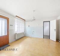 Na predaj 4-izbový rodinný dom, Topoľníky - Interiér rodinného domu s podlahou s dreveným dekorom a bielymi stenami.