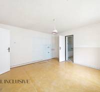 Na predaj 4-izbový rodinný dom, Topoľníky - Priestranná izba v rodinnom dome s podlahou s dreveným dekorom a jednoduchým osvetlením.