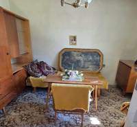 Rodinný dom v obci Pavlovce nad Uhom - Rodinný dom obsahuje jedáleň s kobercovou podlahou, nábytkom a visiacim lustrom.