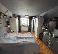 PREDAJ: 3-izbový byt 77 m², Šahy – Výborná investícia aj bývanie  - Spálňa v 3-izbovom byte so skriňou, posteľou a podlahou s dreveným dekorom.