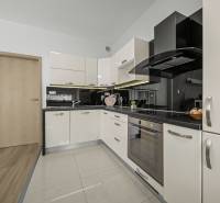 Svetlý 3-izbový byt 90 m² s terasou 18,5 m², 2 garáže, Smaragdová ul. - Kuchyňa v 3-izbovom byte s modernou linkou a podlahou s dreveným dekorom.