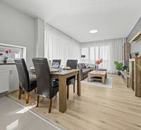 Svetlý 3-izbový byt 90 m² s terasou 18,5 m², 2 garáže, Smaragdová ul. - Svetlá obývacia izba s jedálenským stolom a podlahou s dreveným dekorom v 3-izbovom byte.