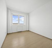 Svetlý 3-izbový byt 90 m² s terasou 18,5 m², 2 garáže, Smaragdová ul. - Svetlá izba s podlahou s dreveným dekorom, oknom a závesmi v 3-izbovom byte.