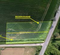 Stavebný pozemok 584m2 | Trenčín - Skalka nad Váhom - Letecký pohľad na pozemky pri ceste; jeden je rezervovaný, druhý na predaj.