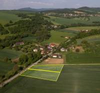 Stavebný pozemok 584m2 | Trenčín - Skalka nad Váhom - Rustikálna krajina s plánovanými pozemkami na bývanie, obklopené lúkami a domami.