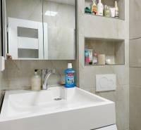 Kompletne zrekonštruovaná garzónka na prenájom, Internátna ulica - Kúpeľňový priestor garsónky s umývadlom, zrkadlom a vstavanými poličkami s kozmetikou.