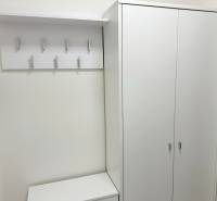 Kompletne zrekonštruovaná garzónka na prenájom, Internátna ulica - Svetlá skriňa a vešiak v garsónke s viacerými háčikmi a bielym stolom.