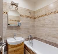 2 izbový prerobený byt v Trenčíne Pred polom, balkón + pivnica - Kúpeľňa v 2-izbovom byte so svetlými obkladmi a vaňou, skrinky pod umývadlom.