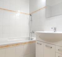 | 2-izbový byt + parking, ul. Východná | Trenčín - Kúpeľňa v 2-izbovom byte s bielymi obkladmi a vaňou.