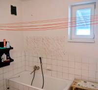 Rodinný dom s veľkou terasou a garážou v  Lastovciach za  73 500 € - Kúpeľňa v rodinnom dome s vaňou, poličkou a bielymi kachličkami.