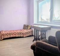 Rodinný dom s veľkou terasou a garážou v  Lastovciach za  73 500 € - Izba v rodinnom dome s rozkladacím gaučom a kreslom, podlaha s dreveným dekorom.