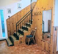 Rodinný dom s veľkou terasou a garážou v  Lastovciach za  73 500 € - Interiér rodinného domu s dreveným obložením, zrkadlom, schodiskom a podlahou s dreveným dekorom.