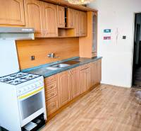 Rodinný dom s veľkou terasou a garážou v  Lastovciach za  73 500 € - Kuchyňa v rodinnom dome s klasickou linkou a podlahou s dreveným dekorom.